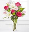
Bursting fresh from the garden, this arrangement of fuchsia roses, pale pink tulips, white Asiatic Lilies, green button poms and lush greens, beautifully seated in a clear glass vase, create the perfe...
			