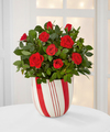 
A bright and beautiful splash of holiday color! A rich red mini rose plant arrives seated in a designer red and white striped ceramic container, lovingly accented with two candy canes amongst its lush...
			